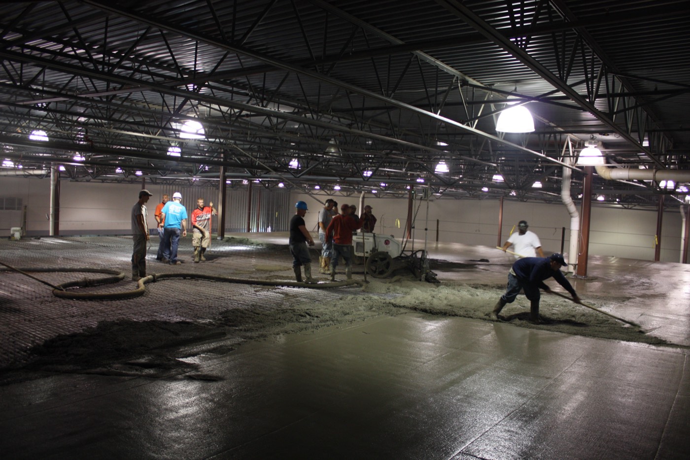Crew placing and finishing a concrete slab pour inside the data center shell.